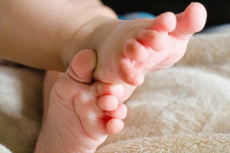 Close-up of a baby's feet resting on a soft blanket