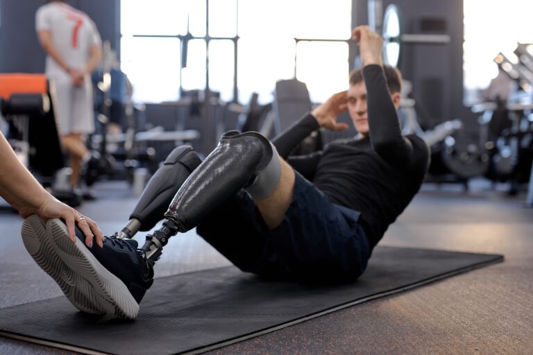 A man with two prosthetic legs doing abdominal exercises in a gym