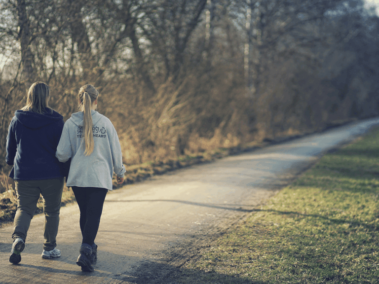 Two people walking together along a quiet path